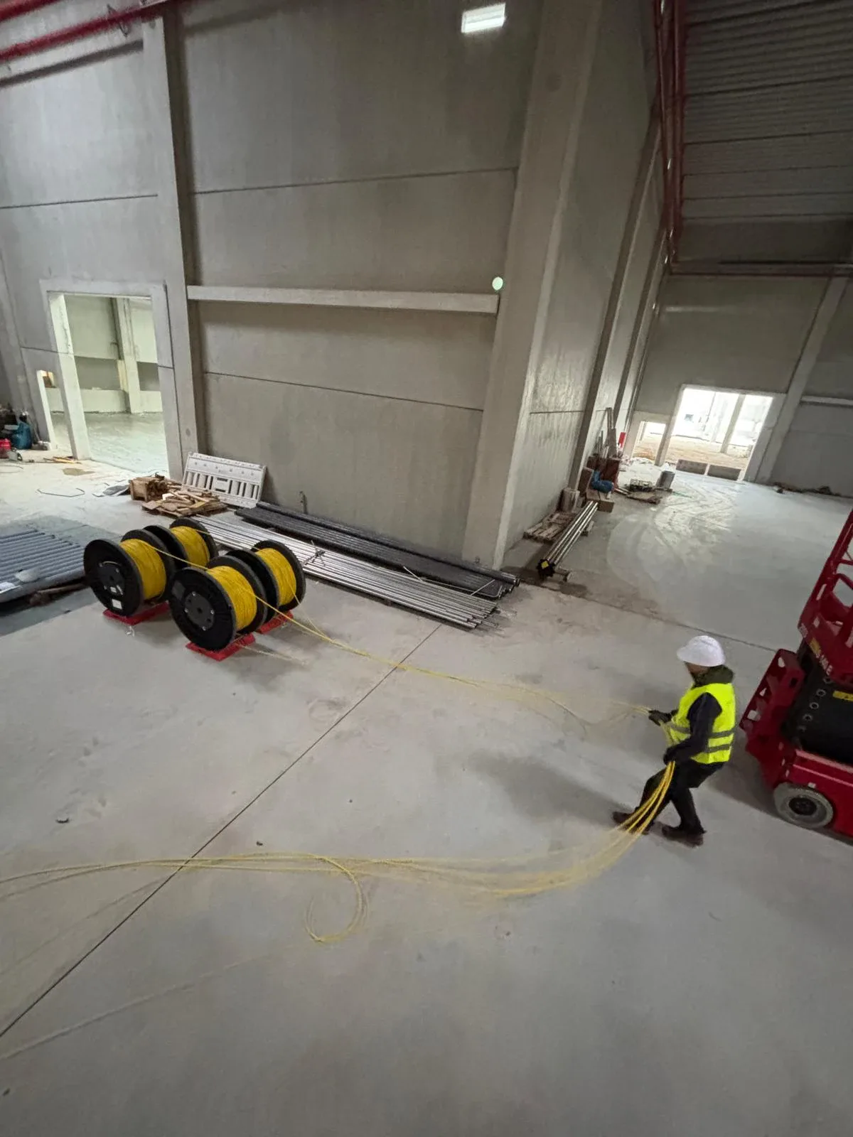 Glasfaserkabel werden in einer grossen Industriehalle verlegt